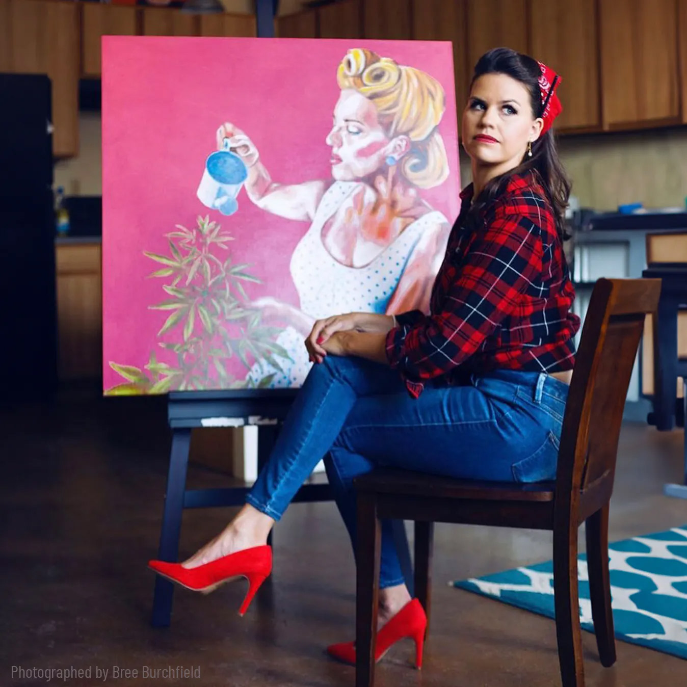 Artist sitting by her panting.